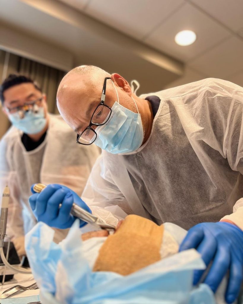 Dentists practicing implant surgery techniques during the Las Vegas AAID Maxicourse hands-on training.