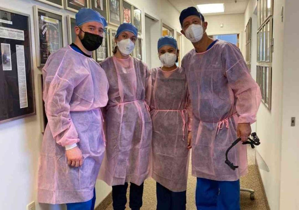 Dental professionals in surgical attire participating in a Live Hands On Implant Surgical Program